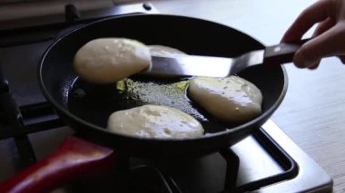 Kızartma tavasında kıtır kıtır Rus gözlemesi pişirmek. Maslenitsa tatili.
