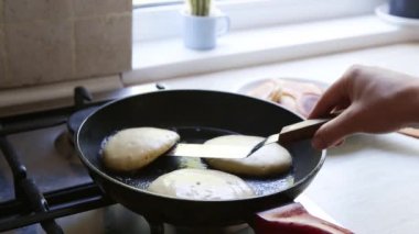 Kızartma tavasında kıtır kıtır Rus gözlemesi pişirmek. Maslenitsa tatili.