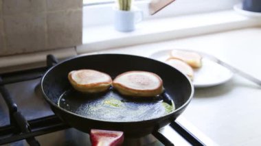 Kızartma tavasında kıtır kıtır Rus gözlemesi pişirmek. Maslenitsa tatili.