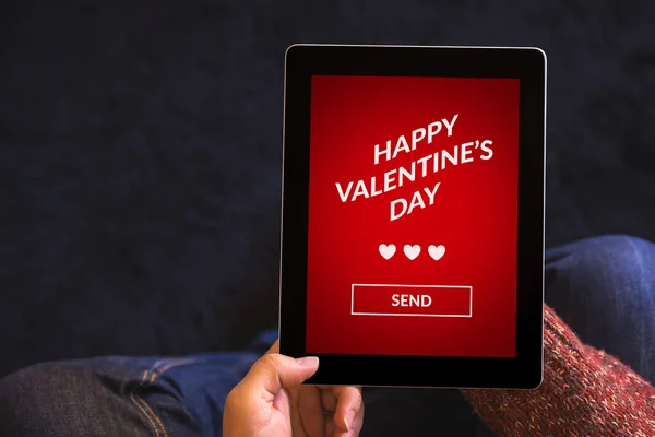 Mãos segurando tablet com conceito de dia dos namorados na tela — Fotografia de Stock