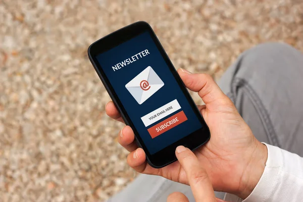 Manos sosteniendo el teléfono inteligente con el concepto de boletín de suscripción en pantalla — Foto de Stock