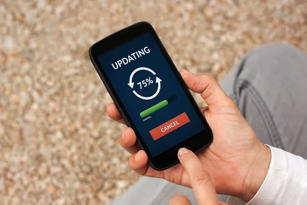 Manos sosteniendo el teléfono inteligente con concepto de actualización en la pantalla — Foto de Stock