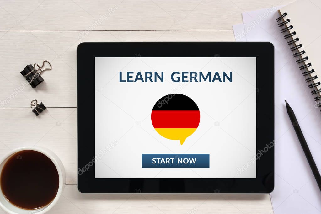 Learn german concept on tablet screen with office objects