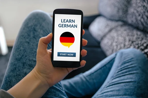 Ragazza in possesso di smart phone con imparare il concetto tedesco sullo schermo — Foto Stock