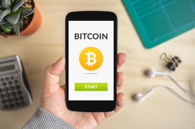 Bitcoin konsepti ile akıllı telefon ekranında tutan el