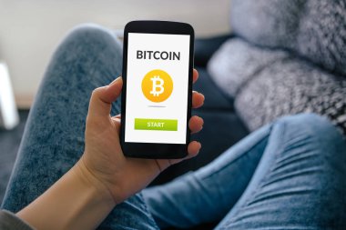 Bitcoin konsepti ile akıllı telefon ekranında tutan kız