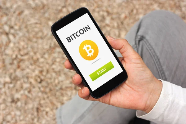 Bitcoin konsepti ile akıllı telefon ekranında tutan el