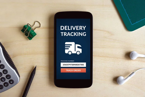 Ahşap masa üzerinde akıllı telefon ekranında kavramı izleme teslim