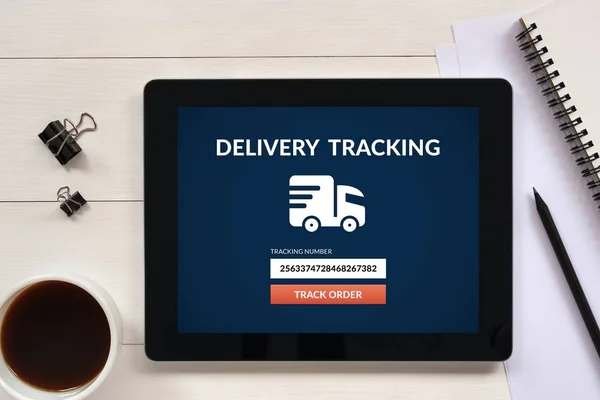 Delivery tracking concept on tablet screen with office objects