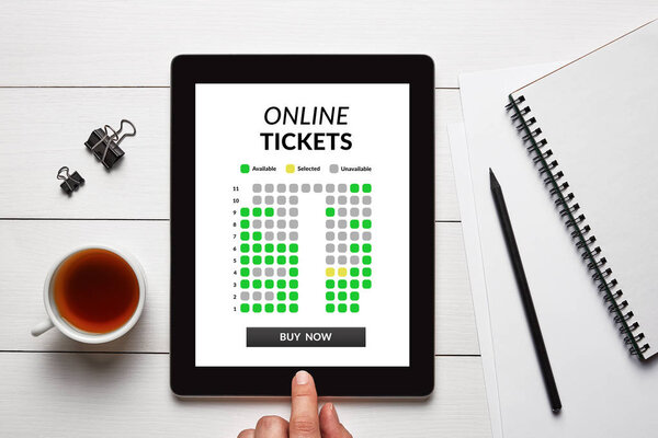 Online tickets concept on tablet screen with office objects 