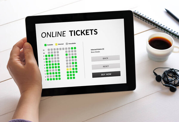 Hand holding tablet with online tickets concept on screen