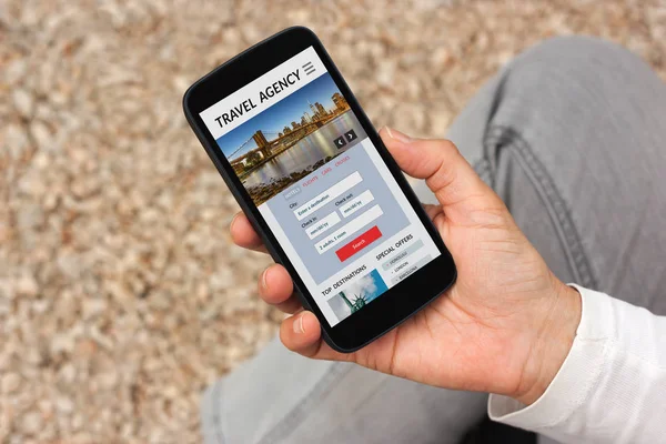 Рука тримає смартфон з концепцією туристичного агентства на екрані — стокове фото