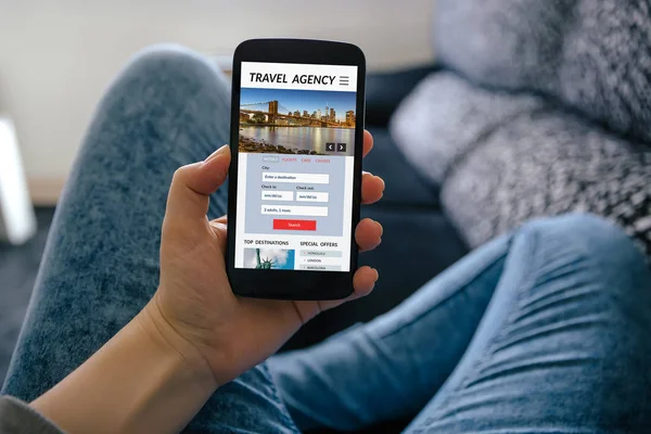 Chica sosteniendo el teléfono inteligente con el concepto de agencia de viajes en pantalla —  Fotos de Stock