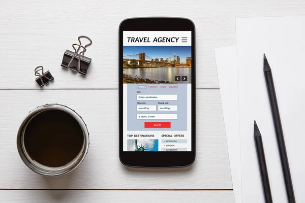 Travel agency concept on smart phone screen with office objects