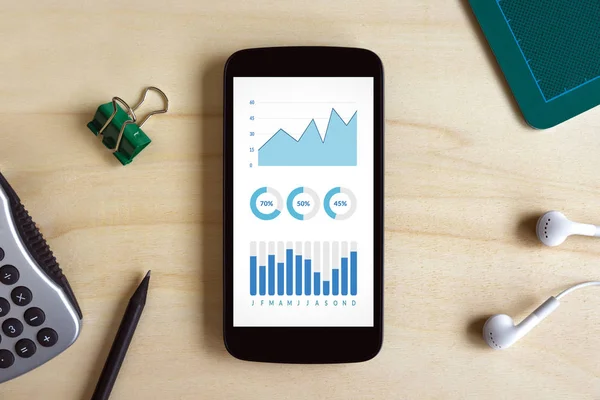 Gráficos y gráficos elementos en la pantalla del teléfono inteligente en escritorio de madera — Foto de Stock