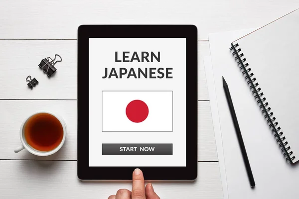 Aprender concepto japonés en la pantalla de la tableta con objetos de oficina — Foto de Stock