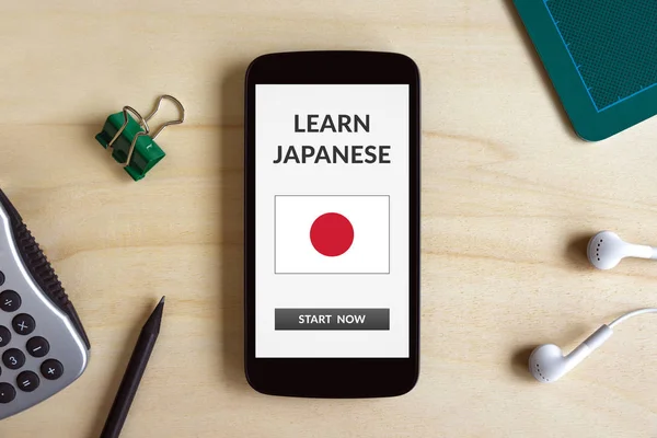 Learn Japanese concept on smart phone screen on wooden desk