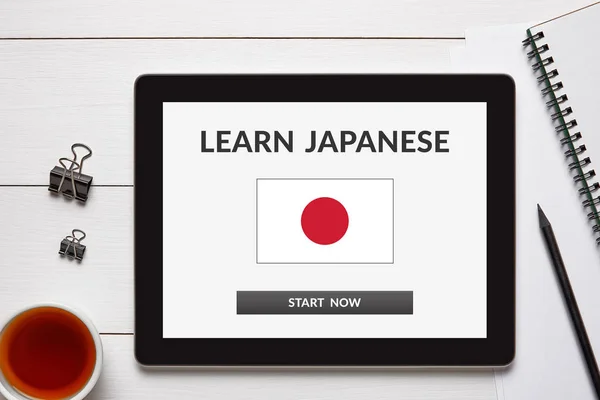 Learn Japanese concept on tablet screen with office objects