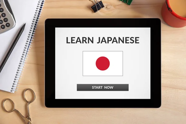 Learn Japanese concept on tablet screen with office objects