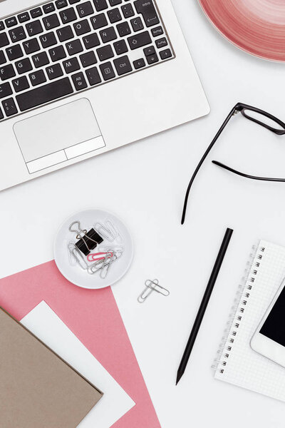 Feminine business desk from above on white background
