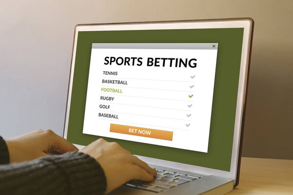Sports betting concept on laptop computer screen on wooden table