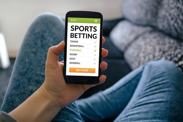 Girl holding smart phone with sports betting concept on screen