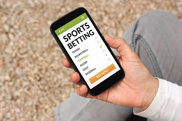 Hand holding smart phone with sports betting concept on screen — Stock Photo, Image