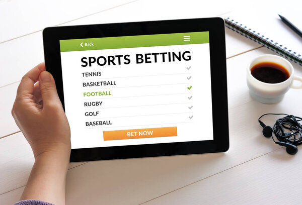 Hand holding tablet with sports betting concept on screen