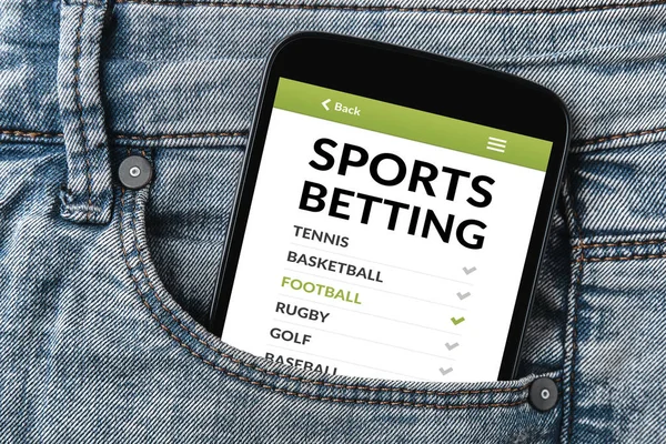 Concepto de apuestas deportivas en la pantalla del smartphone en el bolsillo de los vaqueros — Foto de Stock