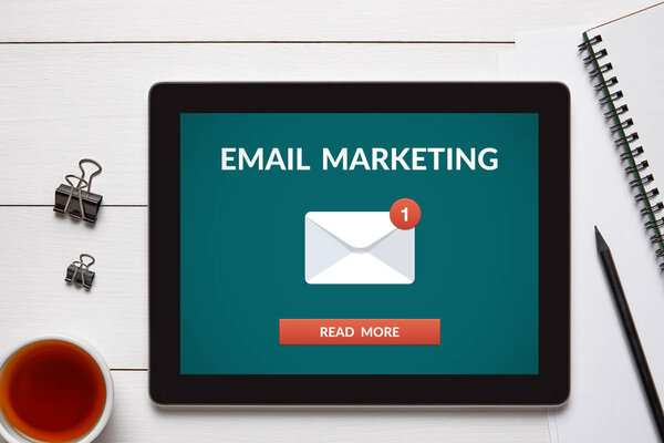 Концепция электронного маркетинга на экране планшета с офисными объектами
