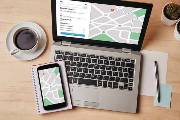 GPS map navigation app on laptop and smartphone screen