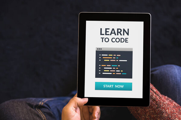 Hands holding tablet with learn to code concept on screen
