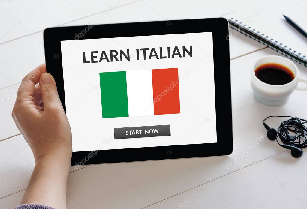 Hand holding tablet with learn Italian concept on screen