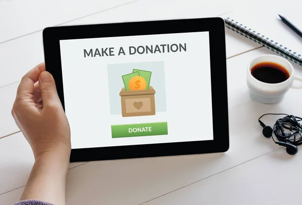 Hand holding tablet with donate concept on screen — Stock Photo, Image