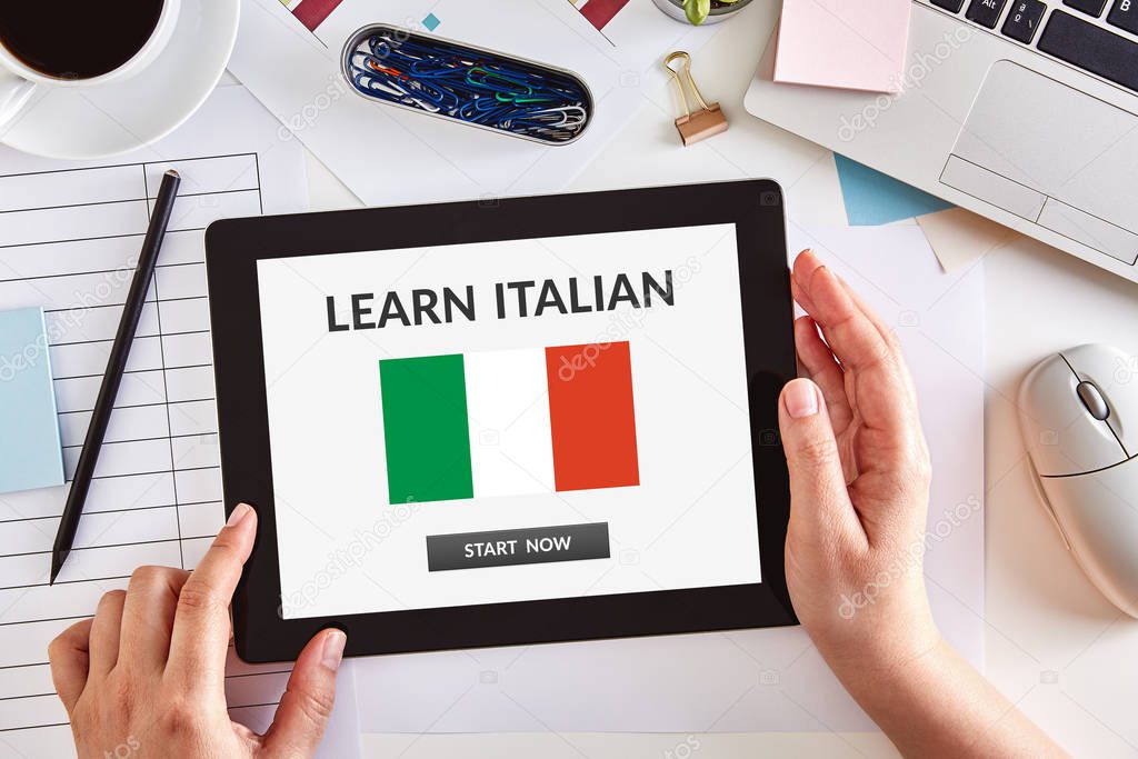 Hands using tablet with learn Italian concept on screen