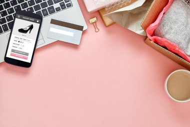 Akıllı telefon ekranındaki kadınlar için çevrimiçi mağaza. Üzerinde fotokopi alanı olan pembe ofis masası var. Kahraman başlığı konsepti. Üst görünüm.