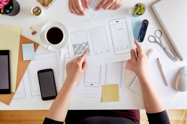 UX grafik tasarımcıları mobil bir uygulamanın yapısını planlıyorlar. Web cep telefonunun kablo çerçeveleme sahnesi. Kullanıcı deneyimi konsepti. Düz yatıyordu