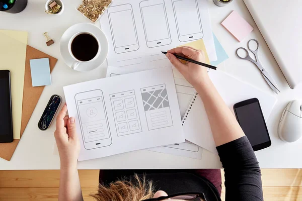 Mobil bir uygulamanın yapısını planlayan genç UX grafik tasarımcısının üst görünümü. Web cep telefonunun kablo çerçeveleme sahnesi. Düz yatıyordu   