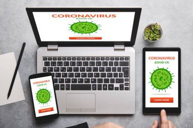 Coronavirus, dizüstü bilgisayarda covid-19 konsepti, tablet ve gri masanın üzerinde akıllı telefon ekranı. Sosyal uzaklık. Düz yatıyordu