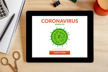 Coronavirus, ahşap masa üzerinde ofis eşyalarıyla dolu tablet ekranda covid-19 konsepti. Sosyal uzaklık. Üst görünüm