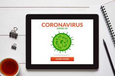 Coronavirus, beyaz ahşap masadaki ofis eşyalarıyla dolu tablet ekranda covid-19 konsepti. Sosyal uzaklık. Üst görünüm