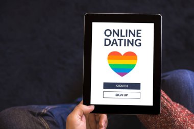 Ekranda LGBT randevu uygulaması konsepti olan dijital tablet bilgisayarı tutan eller. Eşcinsel online randevu. Uzayı kopyala Üst görünüm