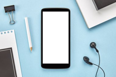 Mavi yüzeyinde beyaz ekranı olan bir akıllı telefonun görüntüsü. Düz yatıyordu