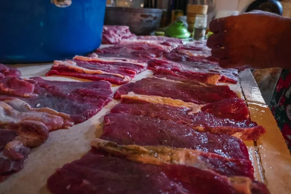 Nyers húsdarabok. Fűszerezés hús háttérben rusztikus konyha, az előtérben. — Stock Fotó