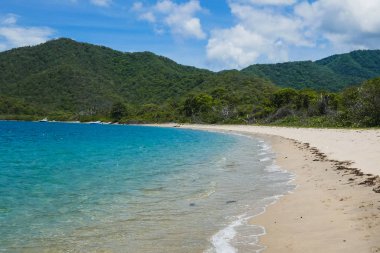 Panorama of a remote Colombian beach of white sand and beautiful vegetation, Tayrona Park, Colombia