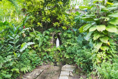 Bahçenin ortasında bir bakirenin heykeli.