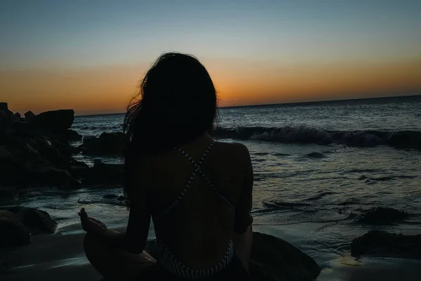 Meditación yoga estilo de vida mujer silueta en la puesta de sol del mar, relajarse vital. Concepto saludable — Foto de Stock