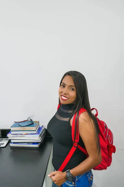 Portrait of a college woman on a white background. The woman has a backpack on her back. Back to school. concept of education