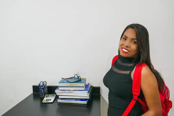 Portrait of a college woman on a white background. The woman has a backpack on her back. Back to school. concept of education