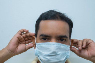 Adam kameraya bakarak maske takıyor. Virüsü kavra